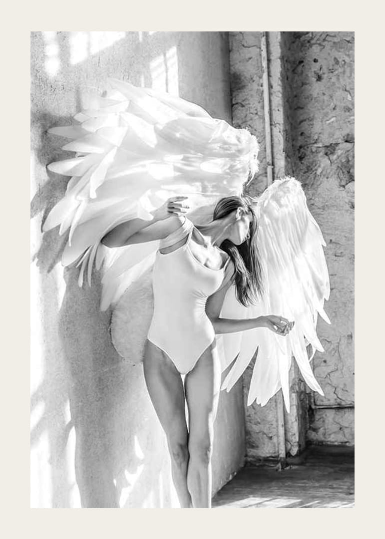 Zwart-witfoto van vrouw met grote witte engelenvleugels-12