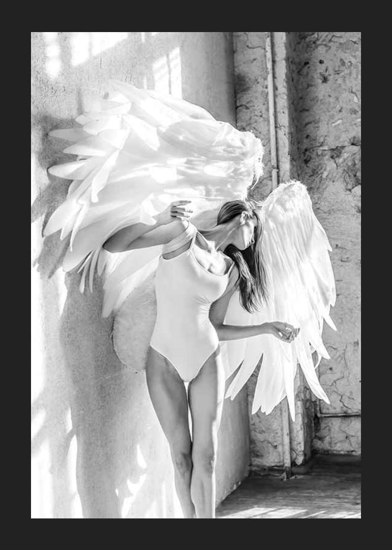 Zwart-witfoto van vrouw met grote witte engelenvleugels-12