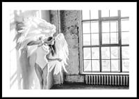 Black and white photo of woman with large angel wings by window-0