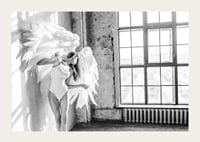 Black and white photo of woman with large angel wings by window-3