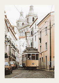 Photograph of yellow tram on narrow cobblestone street in Lisbon-3
