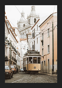 Photograph of yellow tram on narrow cobblestone street in Lisbon-5