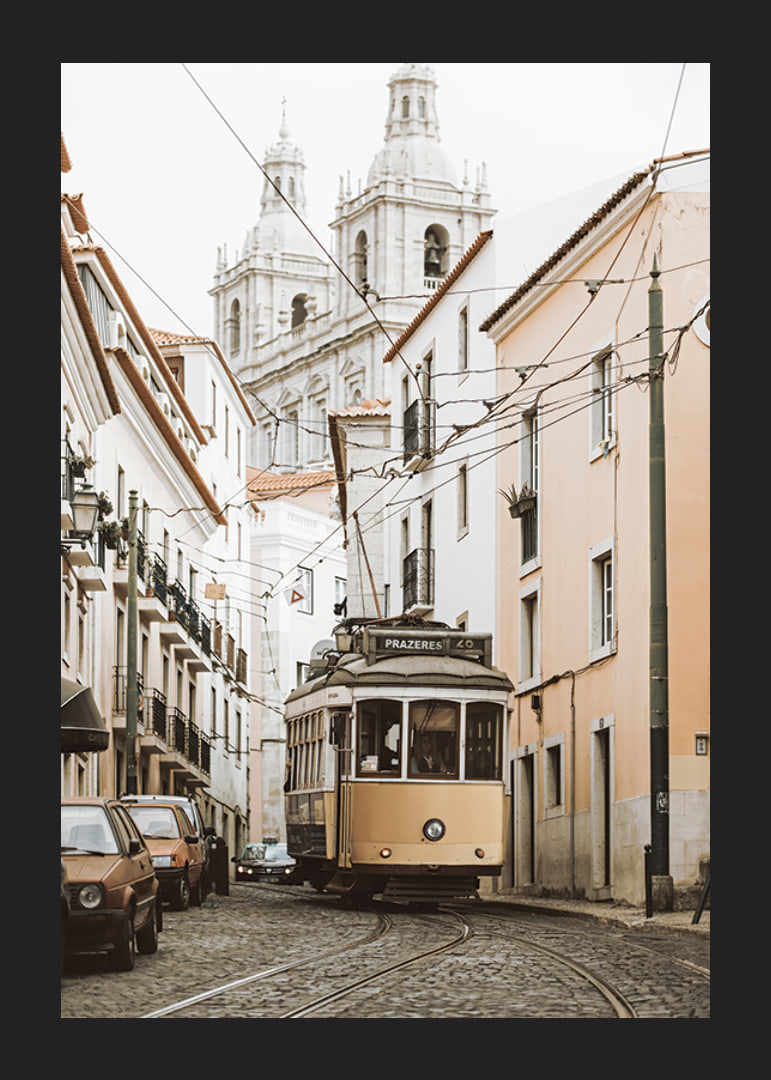 Photograph of yellow tram on narrow cobblestone street in Lisbon-12