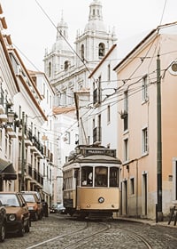 Photograph of yellow tram on narrow cobblestone street in Lisbon-7
