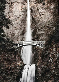 Fotografischer Wasserfall mit weißer Brücke zwischen herbstlich gefärbten Bäumen-7