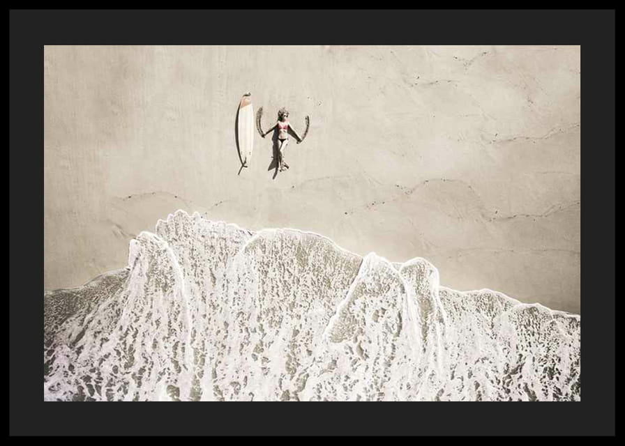 Ylhäältä päin nainen surffilaudan kanssa hiekkarannalla-12