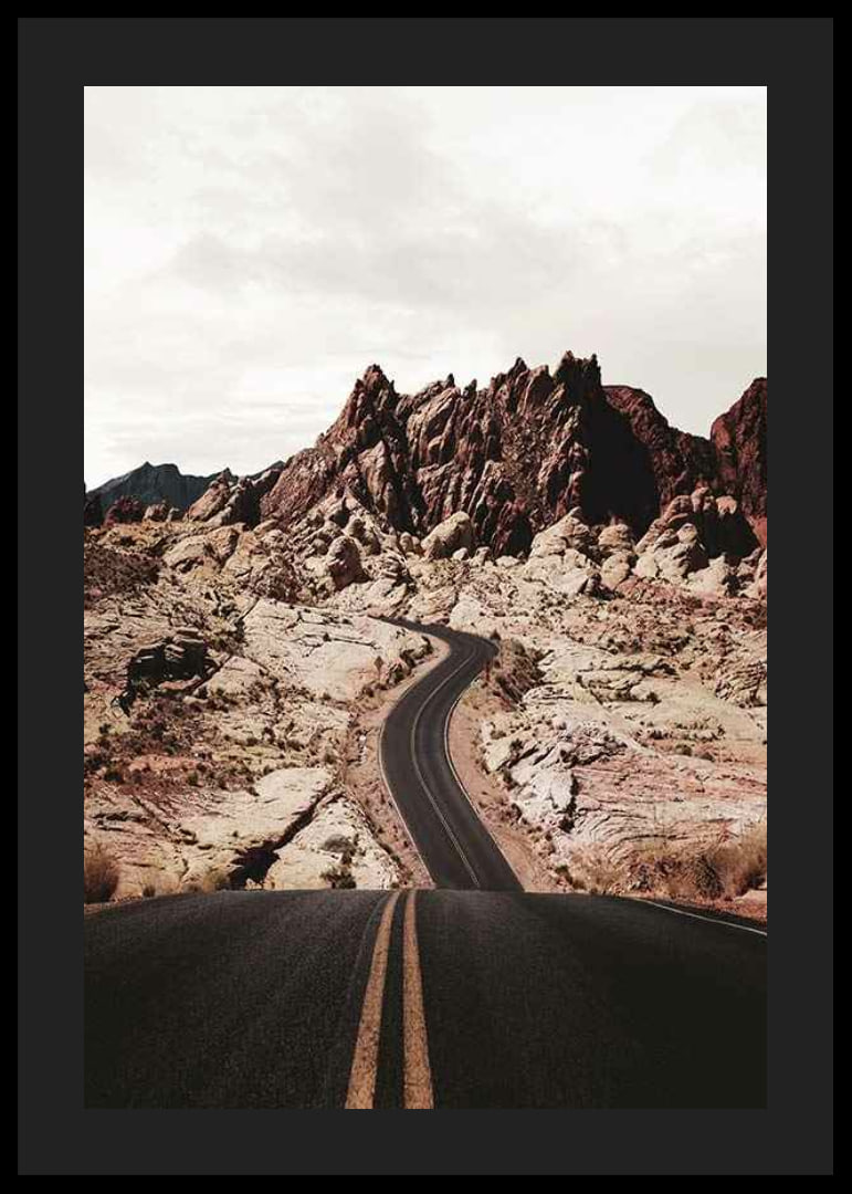 Asphalt road through reddish-brown rocks in desert landscape-12