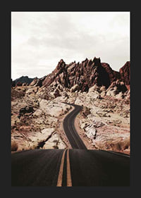 Asphalt road through reddish-brown rocks in desert landscape-5