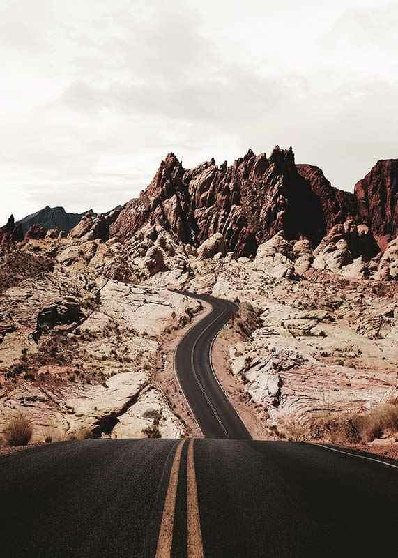 Asphalt road through reddish-brown rocks in desert landscape-12