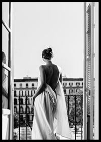 Black and white photo of woman in white dress at open balcony door-6
