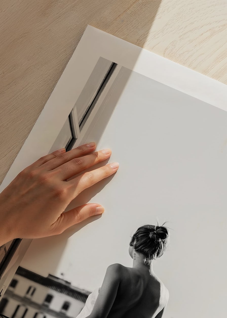 Black and white photo of woman in white dress at open balcony door-12