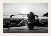 Fekete-fehér fotó egy párról kabrióban naplementekor az óceán felett-3