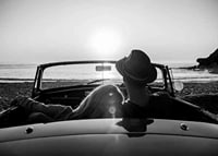 Black and white photography of couple in convertible at sunset over ocean-7
