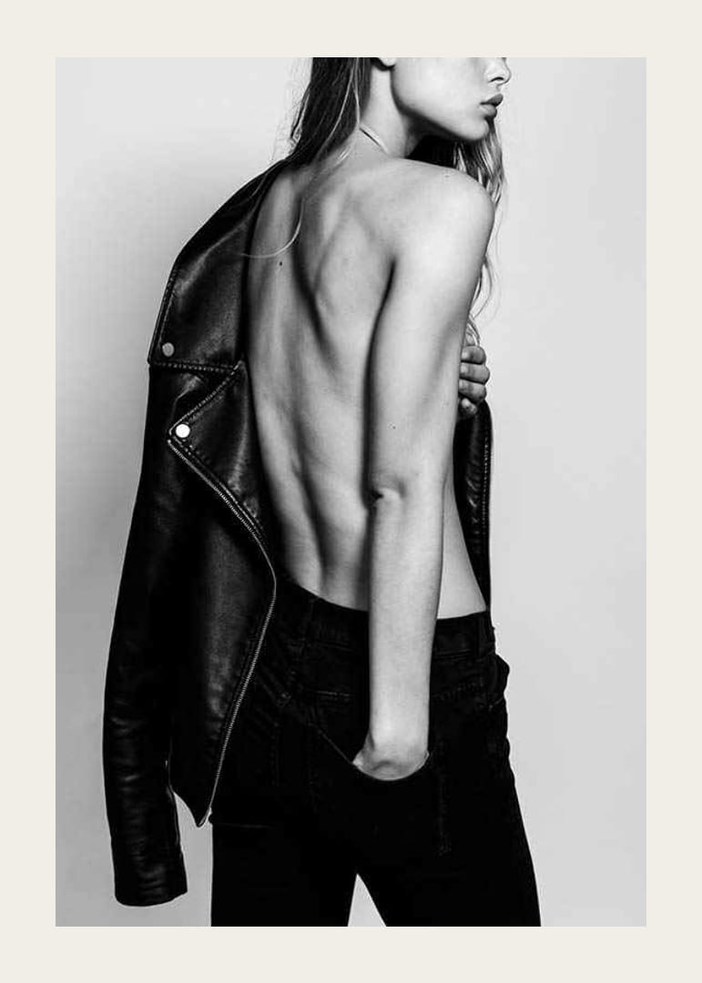 Fotografía en blanco y negro de una mujer joven con vaqueros y chaqueta de cuero.-12