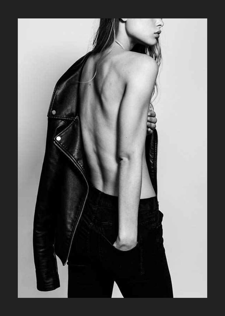 Fotografía en blanco y negro de una mujer joven con vaqueros y chaqueta de cuero.-12