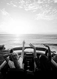 Schwarz-Weiß-Foto von zwei jungen Frauen in einem Cabrio am Meer-7