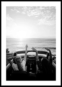 Schwarz-Weiß-Foto von zwei jungen Frauen in einem Cabrio am Meer-0