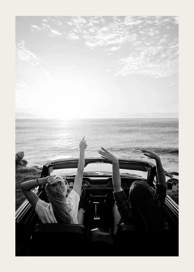 Schwarz-Weiß-Foto von zwei jungen Frauen in einem Cabrio am Meer-12