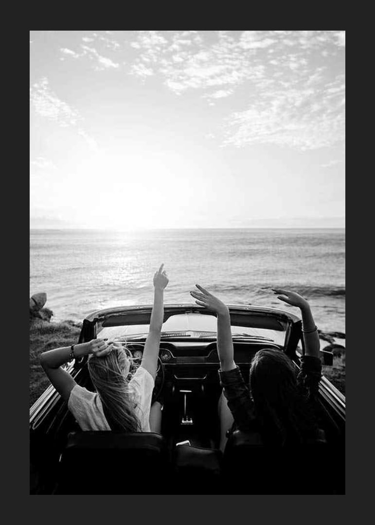 Schwarz-Weiß-Foto von zwei jungen Frauen in einem Cabrio am Meer-12