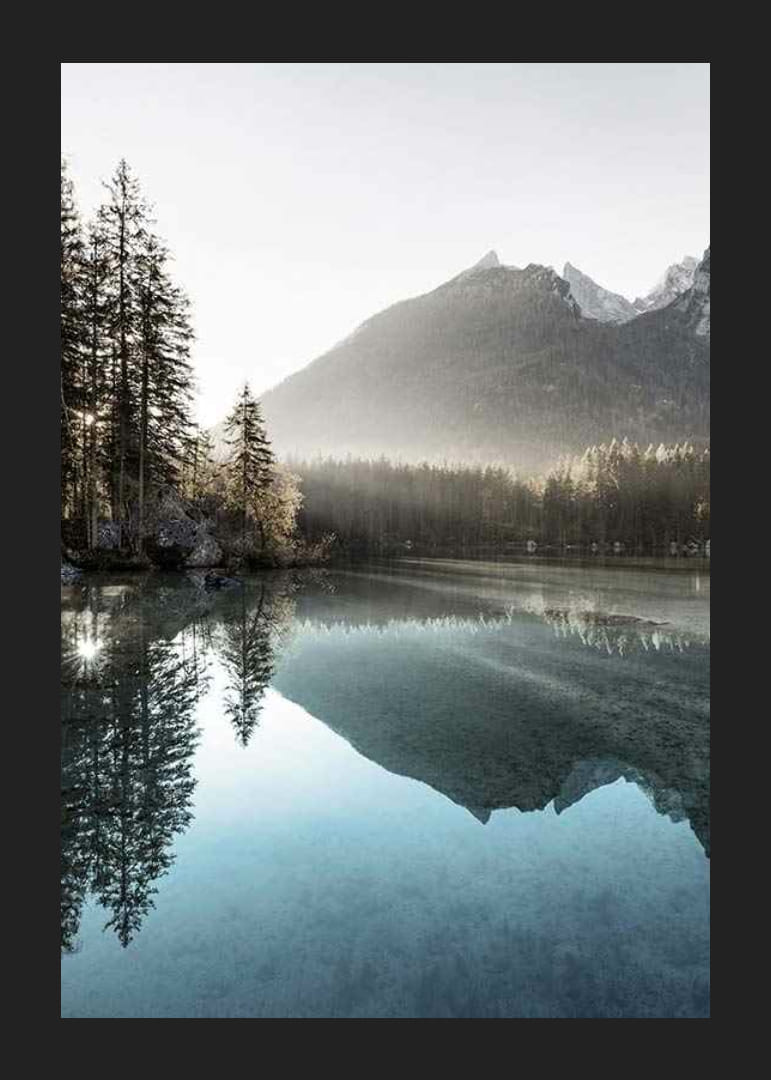 Photograph of calm lake with foggy mountains and fir trees-12