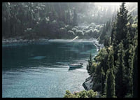 Photograph of lone boat on turquoise water at forested bay-6