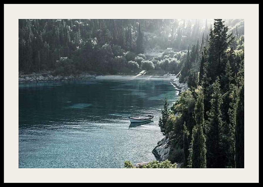 Photograph of lone boat on turquoise water at forested bay-12
