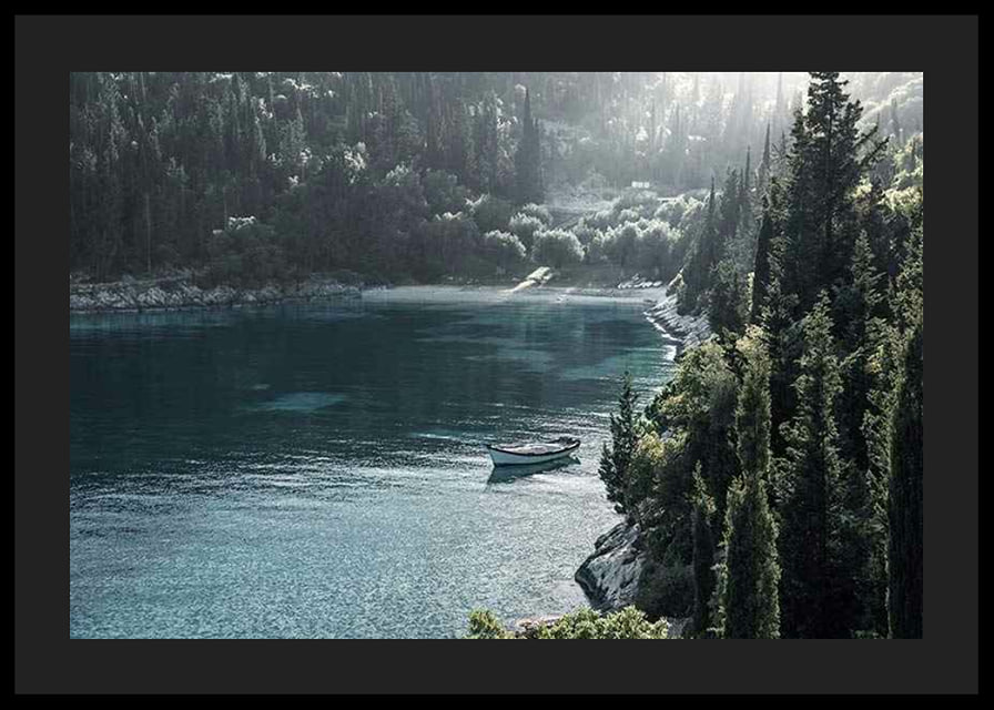 Photograph of lone boat on turquoise water at forested bay-12