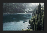 Photograph of lone boat on turquoise water at forested bay-5