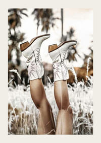 Foto van benen met witte cowboylaarzen in grasveld-3