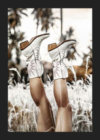 Foto van benen met witte cowboylaarzen in grasveld-5