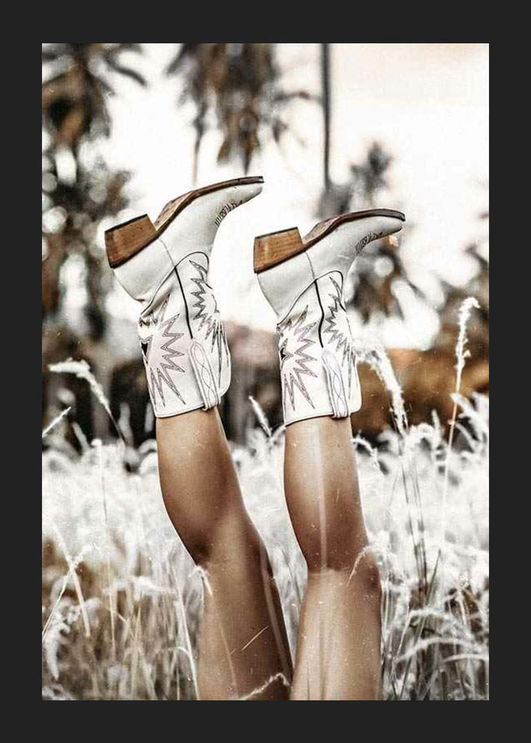 Foto van benen met witte cowboylaarzen in grasveld-12