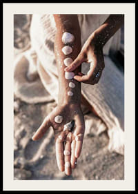 Fotografi av arm med vita snäckor på solig strand-2