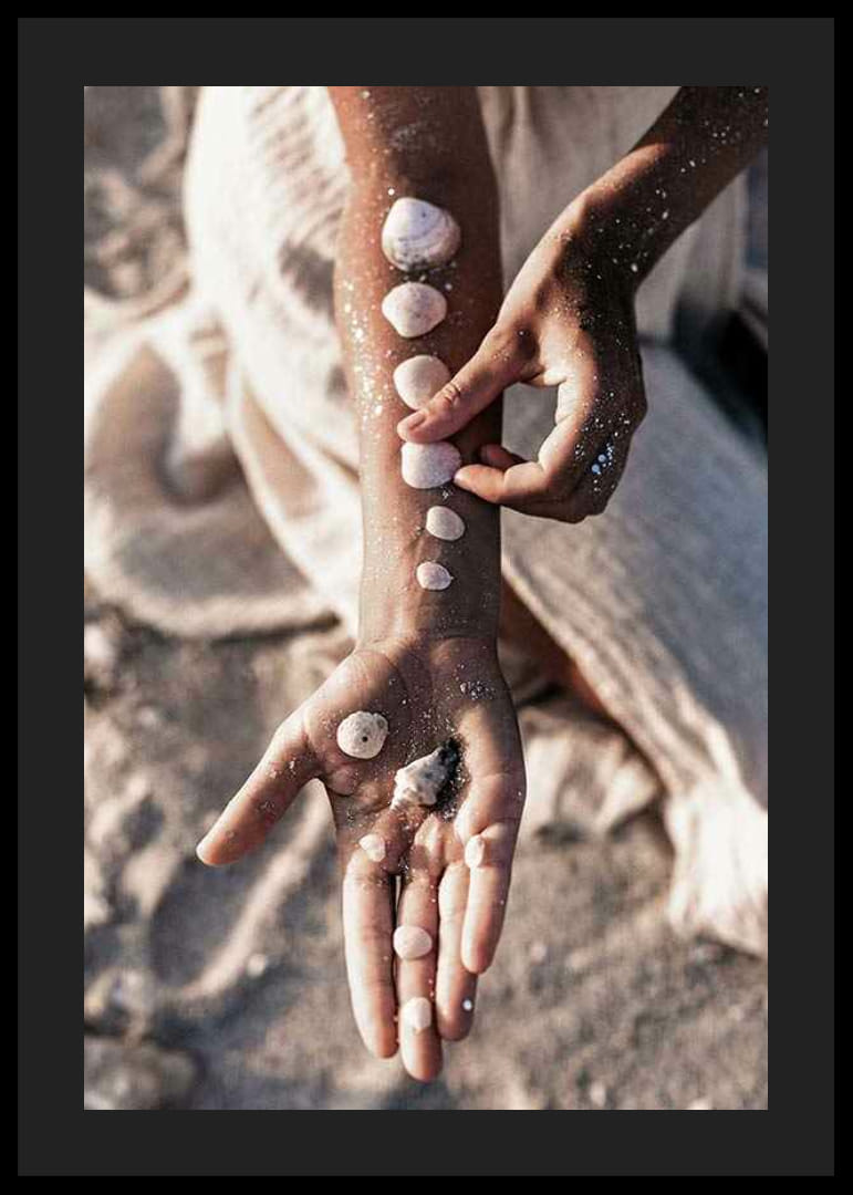 Fotografi av arm med vita snäckor på solig strand-12