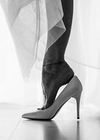 Black and white photograph of woman's feet put in white high heels-7