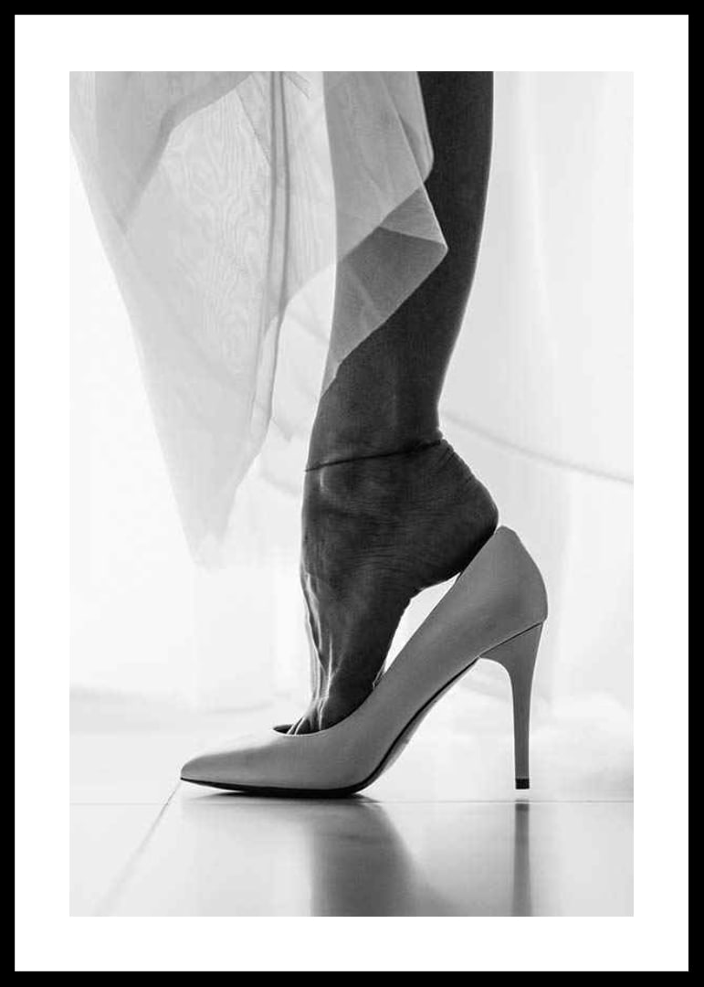 Black and white photograph of woman's feet put in white high heels-12
