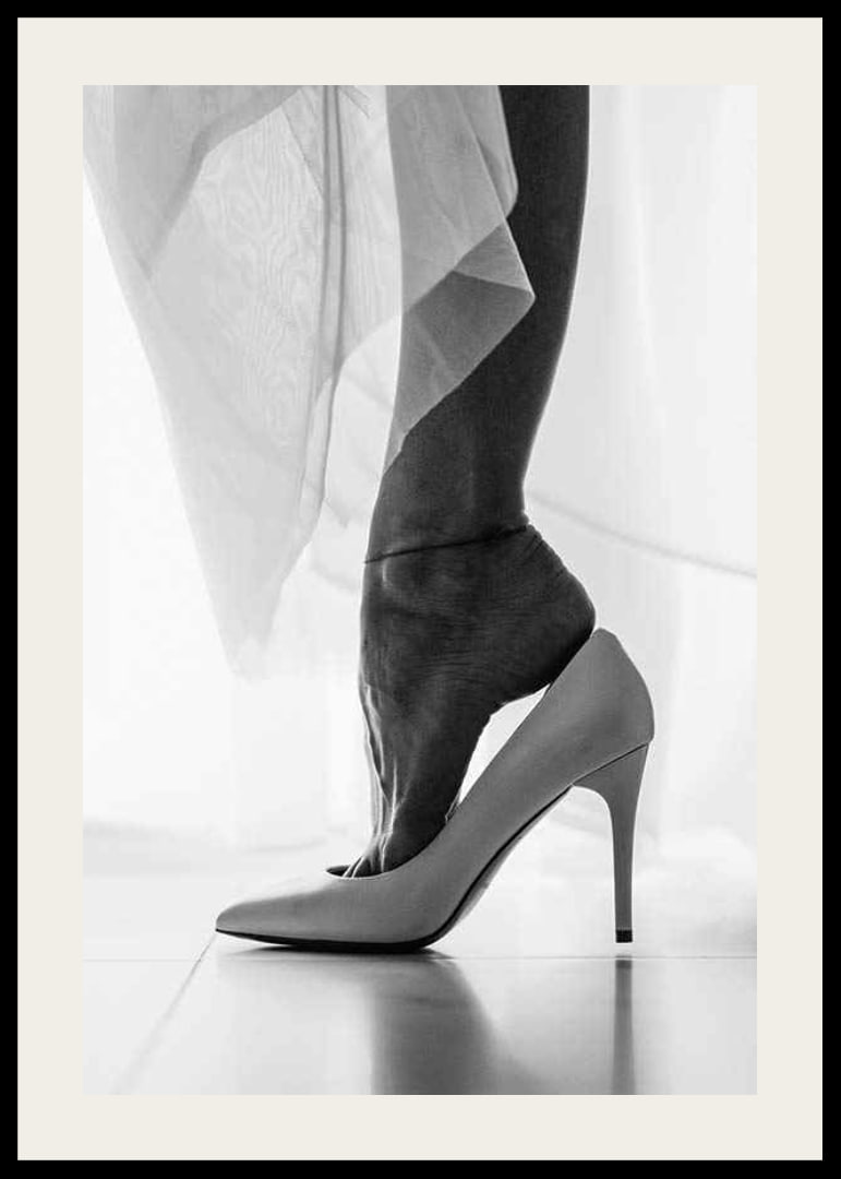 Black and white photograph of woman's feet put in white high heels-12