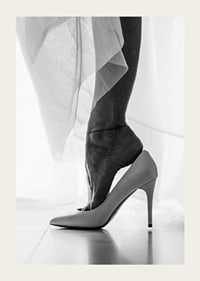Black and white photograph of woman's feet put in white high heels-3
