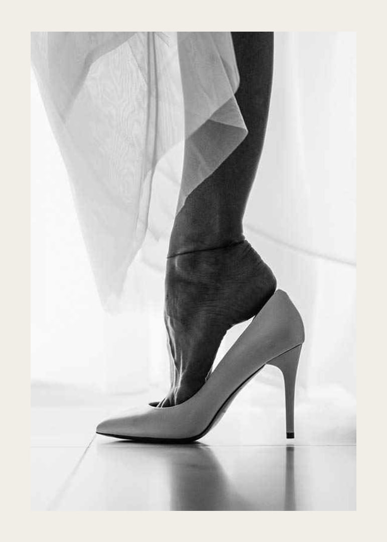 Black and white photograph of woman's feet put in white high heels-12