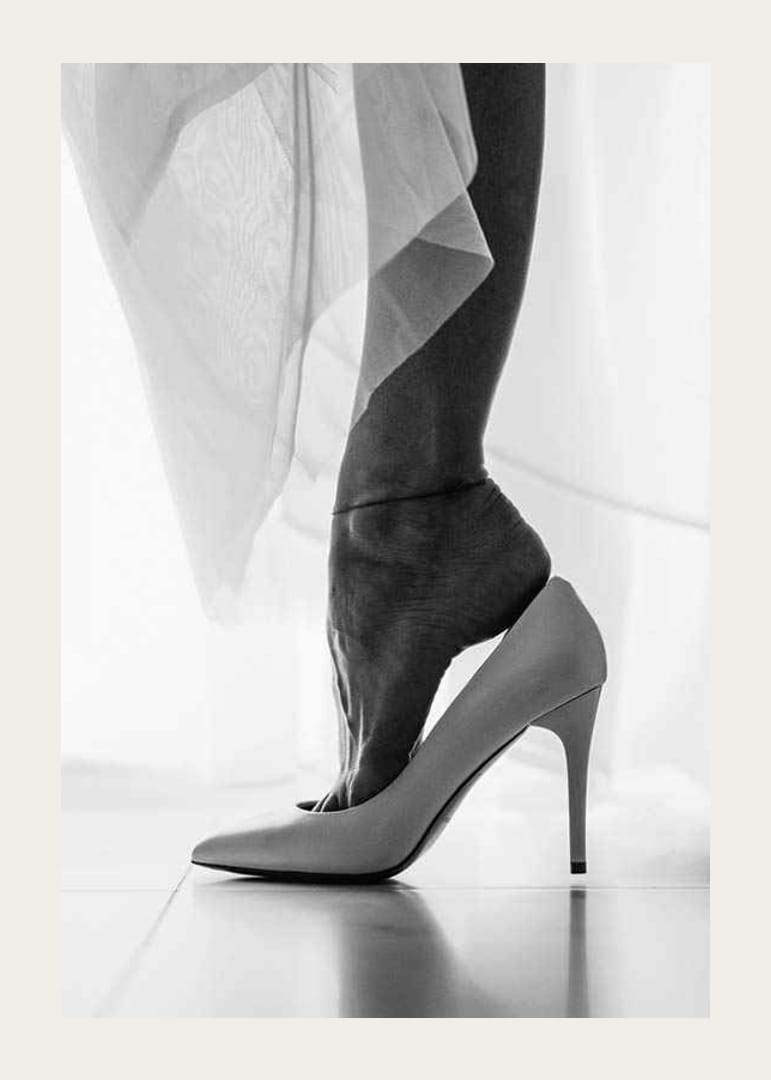 Zwart-witfoto van de voeten van een vrouw in witte hoge hakken-12