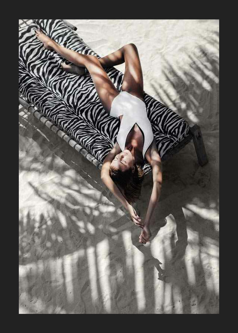 Foto einer Frau im weißen Badeanzug auf einer Sonnenliege mit Zebramuster-12