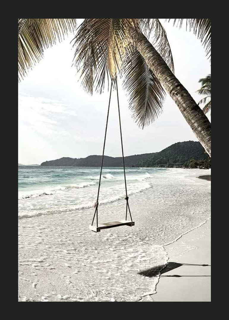 Foto van een eenvoudige houten touwschommel die aan een palmboom op een zandstrand hangt-12