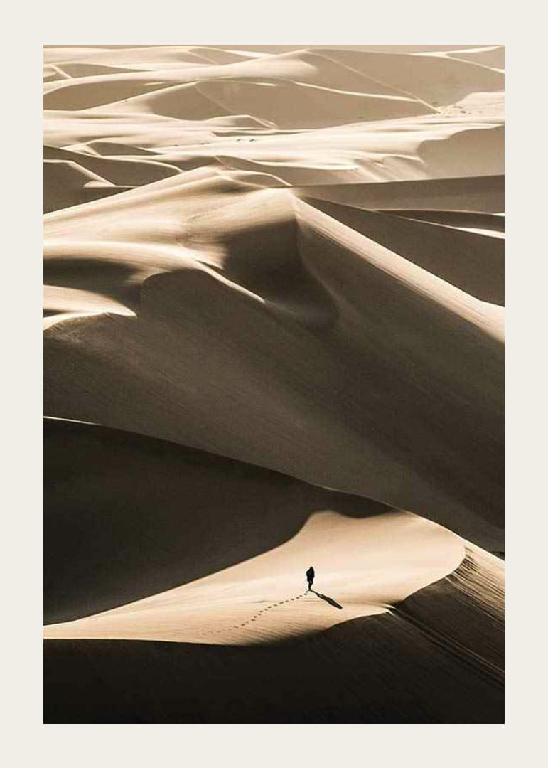 Photographie d'une personne seule sur des dunes de sable ondulantes dans le désert-12