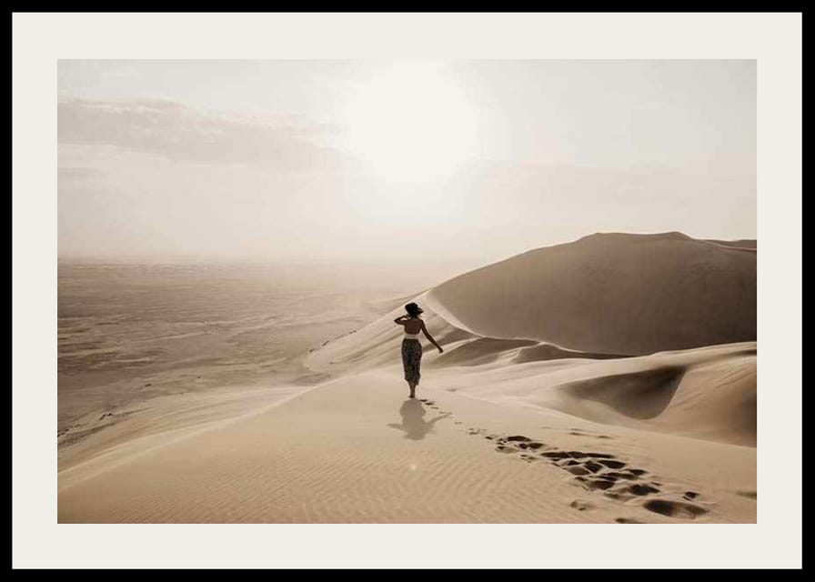 Fotografische vrouw in hoed op zandduinen in hete woestijnomgeving-12