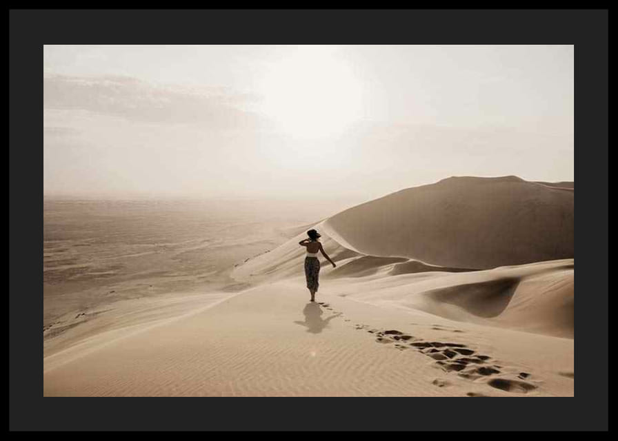 Fotografische vrouw in hoed op zandduinen in hete woestijnomgeving-12