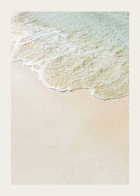 Fotografía de espuma de olas suaves contra una playa de arena en tonos pastel.-3