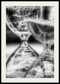 Schwarz-weiße Nahaufnahme von zwei Sanduhren mit fließendem Sand-2