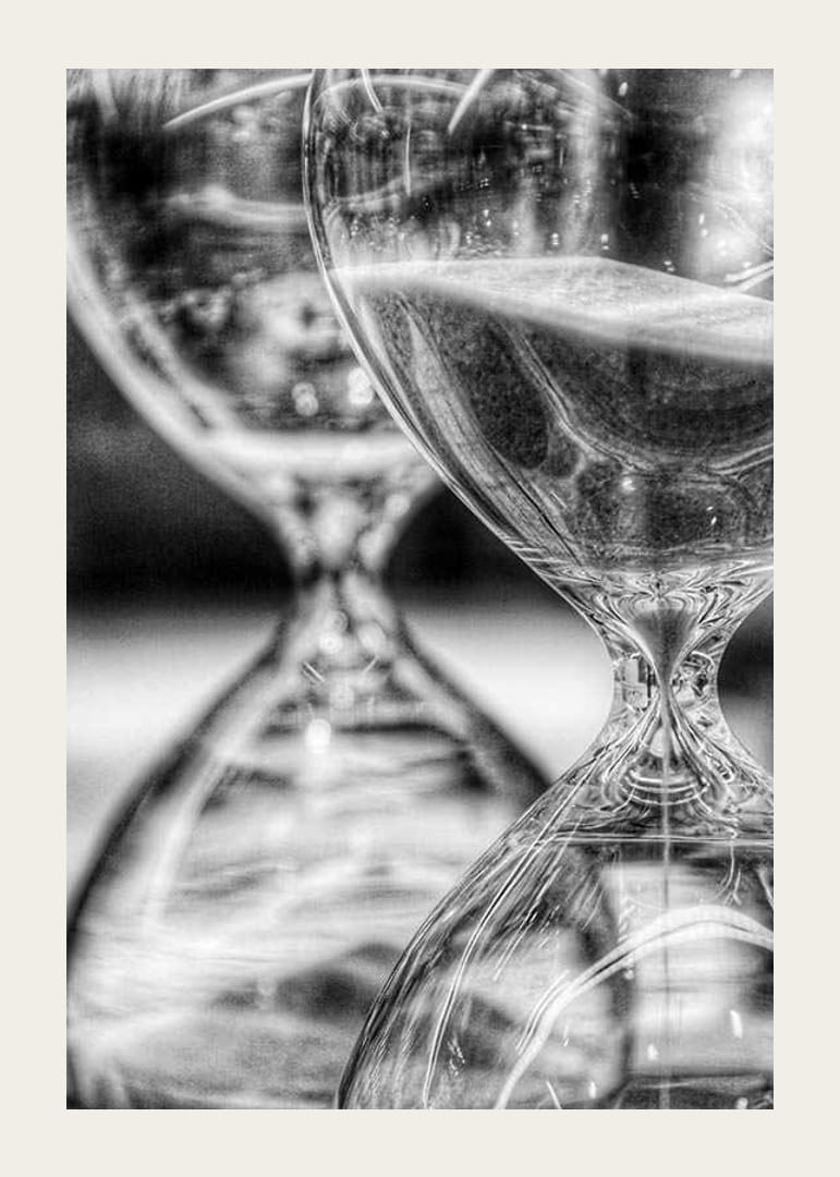 Schwarz-weiße Nahaufnahme von zwei Sanduhren mit fließendem Sand-12