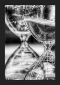 Schwarz-weiße Nahaufnahme von zwei Sanduhren mit fließendem Sand-5