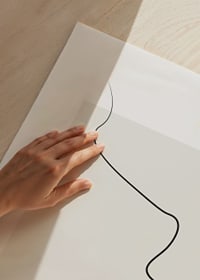 Minimalist line drawing of face profile on beige surface-3