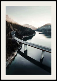 Photographic bridge over calm lake with forested mountains-2